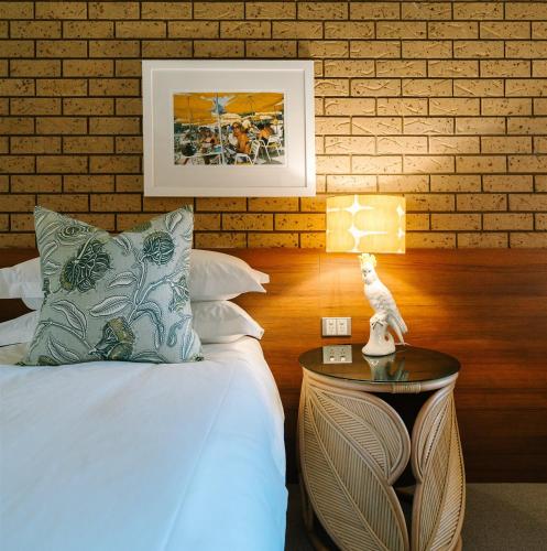 a bedroom with a bed and a table with a lamp at Hara House in Bright