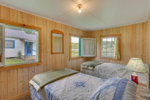 2 camas en una habitación con paredes y ventanas de madera en Honesdale Cabin on 110-Acre Farm Pets Welcome!, en Honesdale