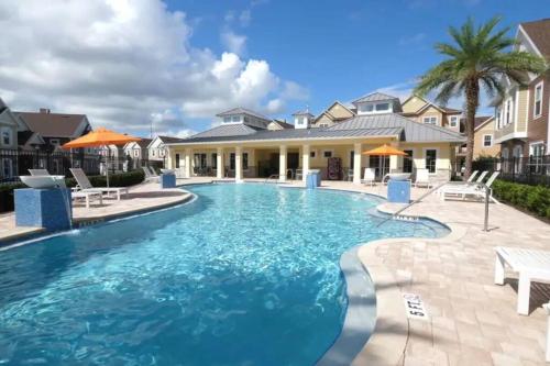 a swimming pool with blue water in front of a house at Magical Wizards Castle in Orlando