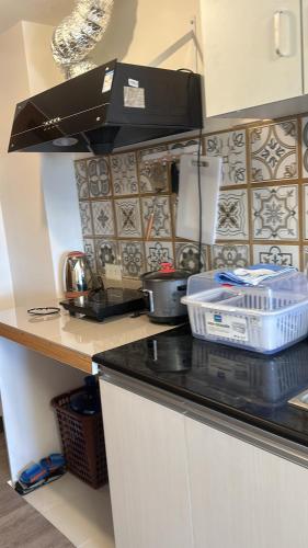 a kitchen with a counter top with a black counter top at Jojies Crib Symfoni Tower 2 Bossa Guadalupe in Cebu City
