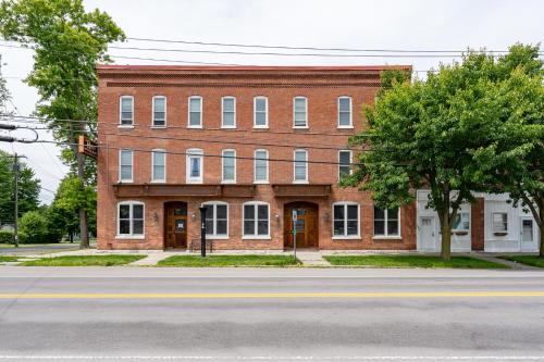 a large brick building on the corner of a street at The Roxy Cape Vincent in Cape Vincent
