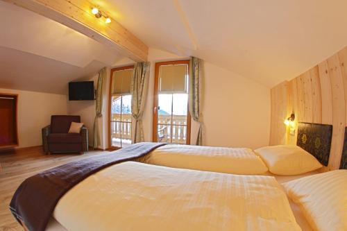 ein Hotelzimmer mit 2 Betten und einem Balkon in der Unterkunft Familien-Bauernhof Neumoar in St. Johann im Pongau