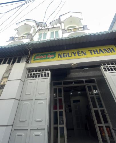 a building with a yellow sign on the front of it at Nguyên Thanh Hotel in Ho Chi Minh City