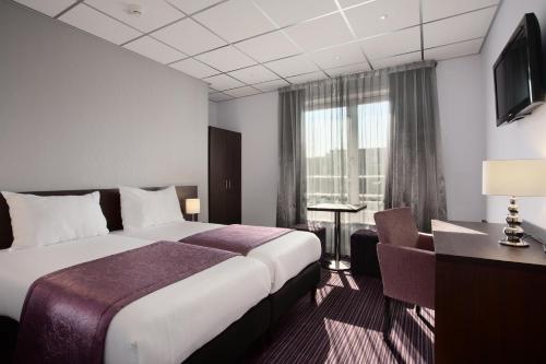 a hotel room with a bed and a window at Hotel Luxer in Amsterdam