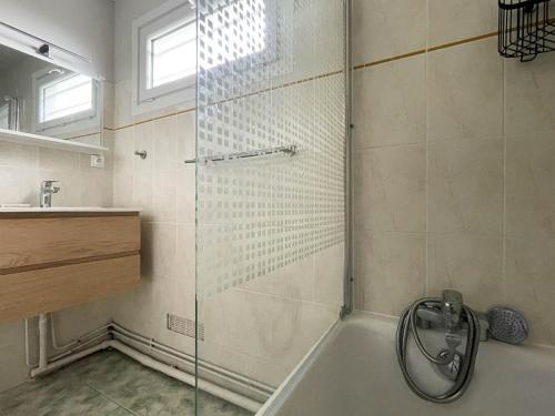 une douche avec une porte vitrée dans une salle de bain dans l'établissement Villa 4 pièces à La Palmyre, proche mer et commerces, patio, barbecue, animaux admis, parking inclus - FR-1-705-40, aux Mathes