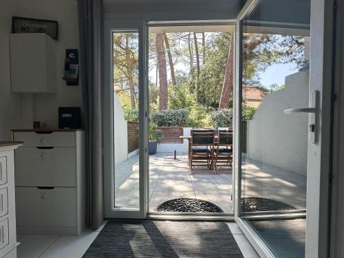 une cuisine avec des portes coulissantes en verre menant à une terrasse dans l'établissement Maison Cosy à La Palmyre - 4 Pers, Terrasse, Wifi, Plage à 1 km - FR-1-705-62, aux Mathes