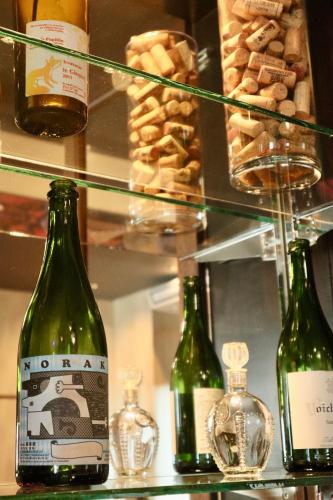 drei Flaschen Wein stehen auf einem Regal mit Gebäck in der Unterkunft Rose hakodate in Hakodate