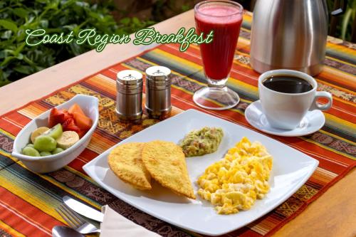 a table with a plate of breakfast food and a cup of coffee at Friends Hotel & Rooftop - Historic Center & Museums in Quito