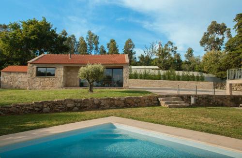 una villa con piscina di fronte a una casa di Casas d'Oliva a Caramulo