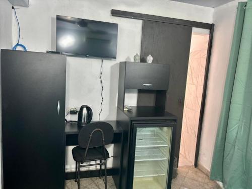 a desk with a chair and a television on a wall at Apartamentos Victoria habitación Green in Asuncion