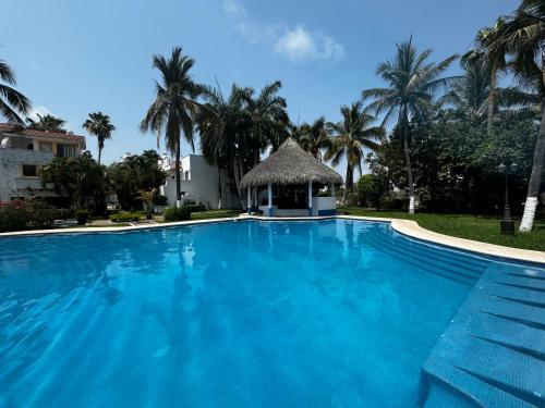 a large blue swimming pool with a gazebo at Casa Marina Maza Vista al Mar 12 Personas in Mazatlán