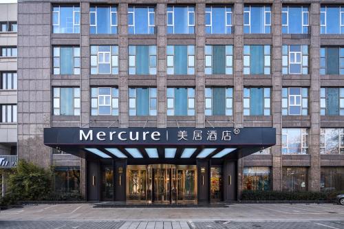 a large building with a sign that reads mentore at Mercure Yiwu International Trade City in Yiwu