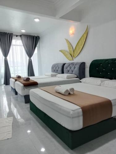 a room with three beds in a room at Perhentian Bay Chalet in Perhentian Island
