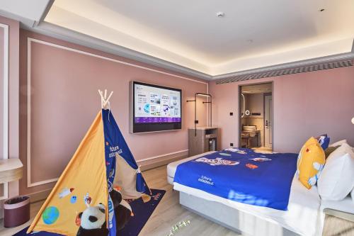 a bedroom with a bed and a tv on the wall at Mercure Yiwu International Trade City in Yiwu