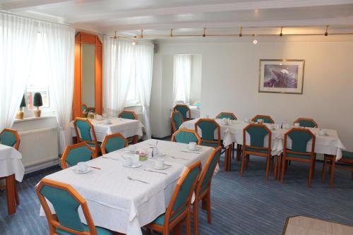 a dining room with white tables and chairs at Hotel Sonne in Leinfelden-Echterdingen