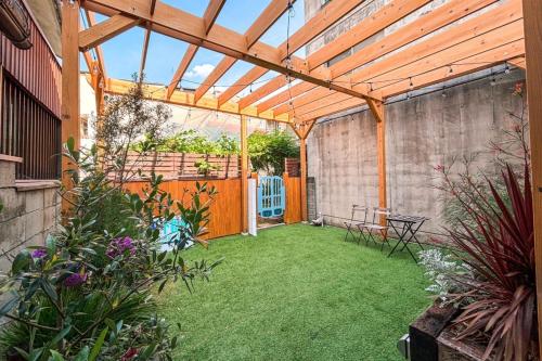 a patio with a wooden pergola and grass at Traditional Apartment Takamatsu Guesthouse in Takamatsu
