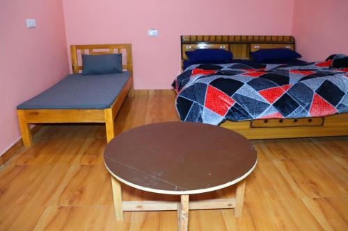 a bedroom with a bed and a table and a bench at Sattva Retreat One Bedroom Chalets in Almora