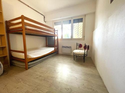 Cette chambre comprend 2 lits superposés et une chaise. dans l'établissement Appartement 3 pièces avec jardin, proche du port et du centre, idéal pour vacances à Banyuls-sur-Mer - FR-1-309-465, à Banyuls-sur-Mer