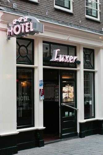 a store front of a hotel with a neon sign at Hotel Luxer in Amsterdam