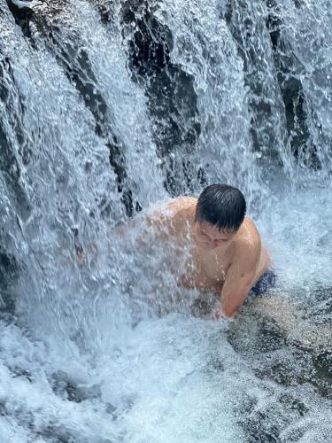 a young boy playing in a waterfall at Zhangjiajie Highlights Guesthouse in Zhangjiajie