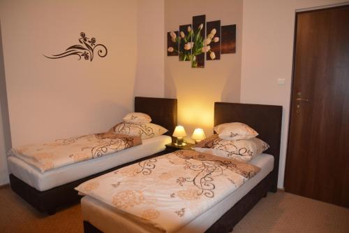 two beds in a room with two lights on at Astra Apartments in Oświęcim