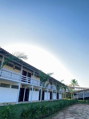 a building with palm trees in front of it at Lagamar Hotel Varginha in Varginha