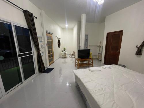 a white bedroom with a bed and a television at ภูผา เฮ้าส์ รีสอร์ท in Ban Mung