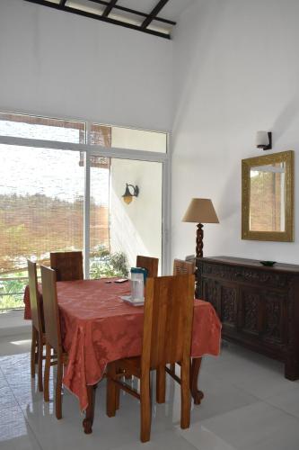a dining room with a table and chairs and a window at SaDev Lake Villa Bandaragama in Bandaragama