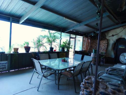 a patio with a table and chairs and a clock at Di's Dugouts in Coober Pedy