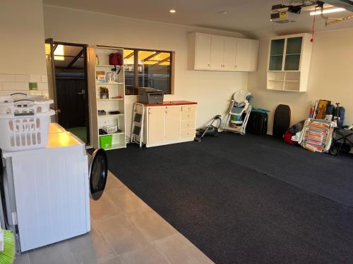 an empty room with a kitchen and a room with a room at Salty Breeze Beach House in Orewa