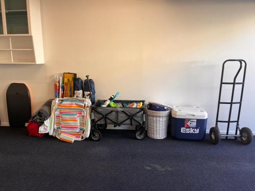 a corner of a room with a cart and trash cans at Salty Breeze Beach House in Orewa