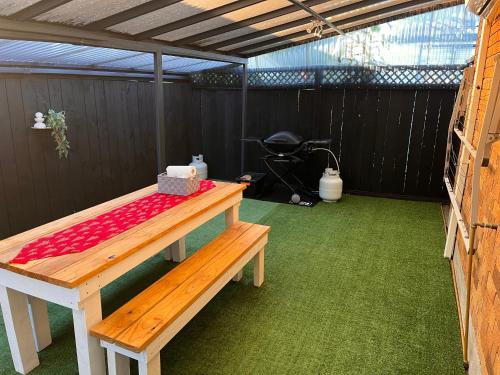 a room with a table and a bench in a shed at Salty Breeze Beach House in Orewa
