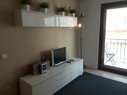 una sala de estar con TV en una cómoda blanca en Estrella Primero De Mayo, en Sitges