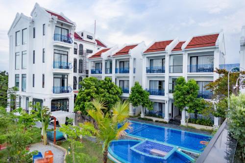 an apartment building with a swimming pool in front of it at Serene Nature Hotel & Spa in Hoi An