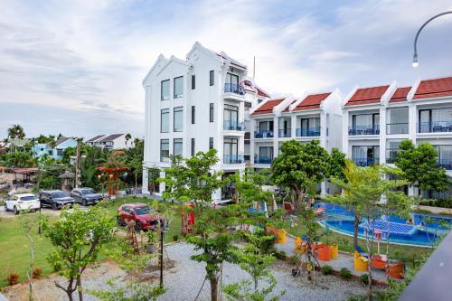 an apartment building with a garden in front of it at Serene Nature Hotel & Spa in Hoi An