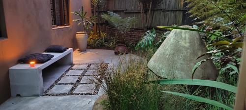 a garden with a bench in the middle of a yard at Dar Amane Guest House in Graskop