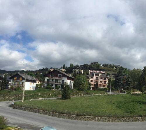 un groupe de maisons sur le flanc d'une colline dans l'établissement Les Appartements Du Père Castor-Self Check-In, à Font-Romeu-Odeillo-Via