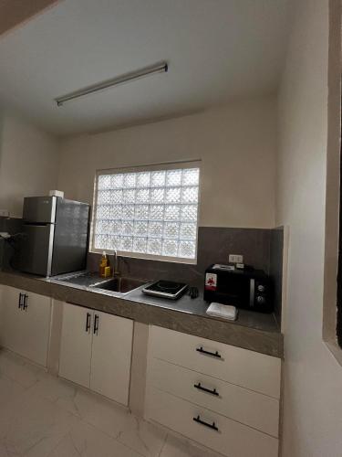 a kitchen with a sink and a microwave at Tuguegarao 3Bedroom Apartment in Tuguegarao City