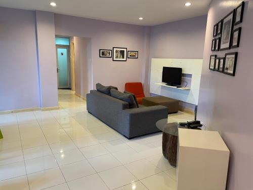 a living room with a couch and a tv at Song Service Apartment formerly known as Jinhold Service Apartment in Kuching