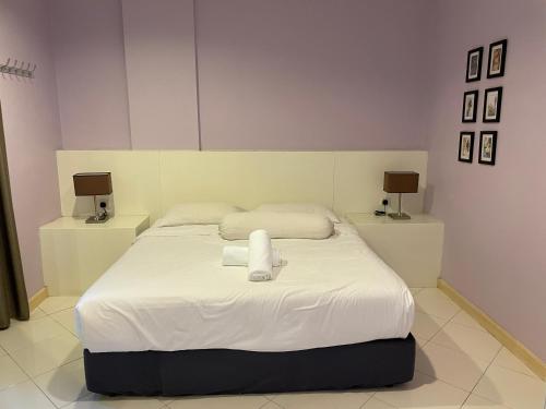 a bedroom with a bed with two towels on it at Song Service Apartment formerly known as Jinhold Service Apartment in Kuching