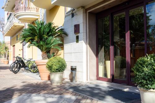 a building with potted plants in front of a store at Hotel Cala Del Porto in Vibo Valentia Marina