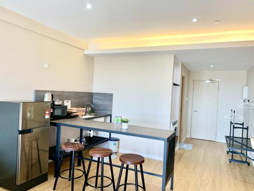 a kitchen with a counter and stools in a room at Deco Home @ Aru Suites in Kota Kinabalu