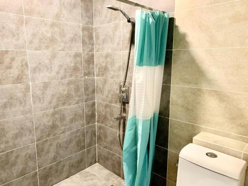 a shower with a blue shower curtain in a bathroom at Deco Home @ Aru Suites in Kota Kinabalu