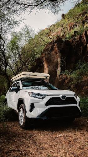 a white and black car parked on a dirt road at CampCar Maui Jeeps SUVs Hybrid Camper van Rentals with equipment and Travel Advice in Kahului