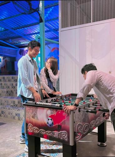 a group of people playing a game on a table at BaobaBed Lodge, Yangon in Yangon