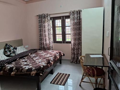 Un dormitorio con una cama y un escritorio y una ventana. en Gungun Homestay, en Rishīkesh