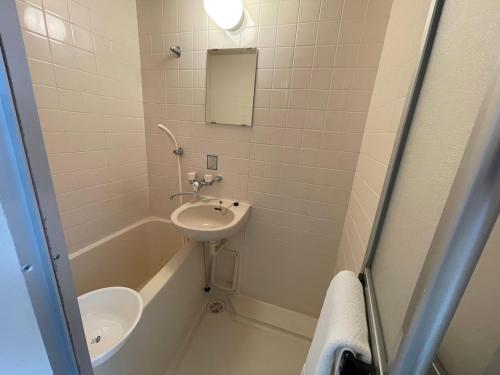 a bathroom with a sink and a tub and a toilet at Endless Mitsui Minami 5jo II in Sapporo