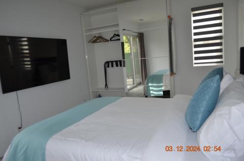 a bedroom with a large white bed with blue pillows at Dimond Abode Vacation Home #1 Oakland Dimond District in Oakland