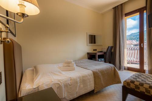 a bedroom with a bed and a desk and a window at Hotel Cala Del Porto in Vibo Valentia Marina