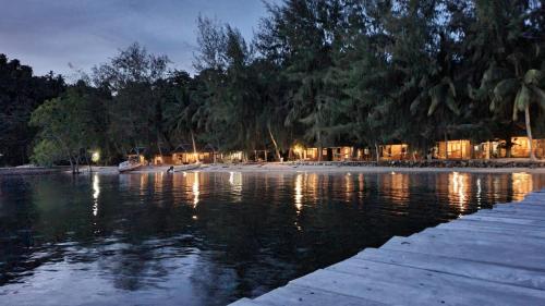 a body of water with a beach at night at Fadhila Cottages in Katupa